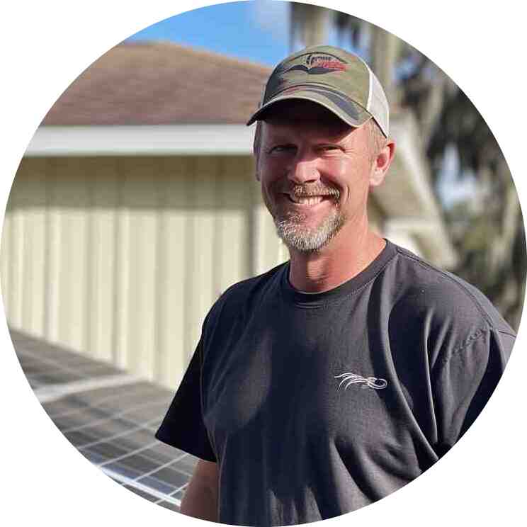 gregory woolman, employee and solar expert with panels in the back